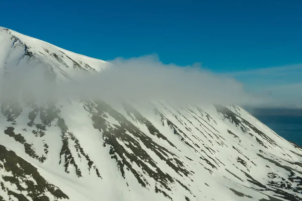 阳光普照的山体上覆盖着雪. — 图库照片