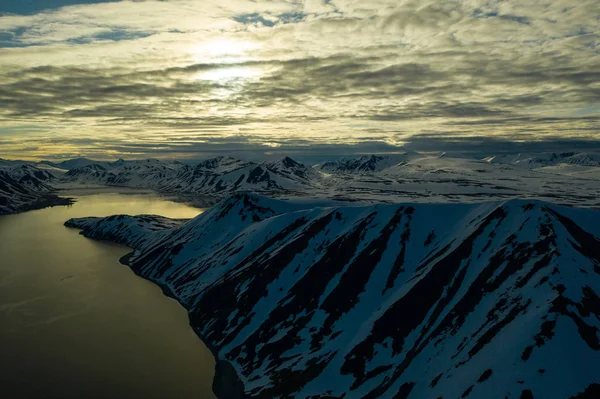 Dağlık sahil güneşli karla kaplı.
