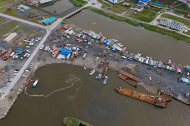 Anadyr, Rusya - 24 Temmuz 2019: Anadyr şehrinin yerleşim yerleri, kıyıları ve tekneleri görünüyor. Yukarıdan ateş ediliyor.