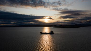 Günbatımının arka planında bir deniz gemisi.