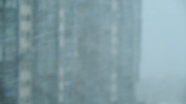 Yoğun kar yağıyor. Güçlü bir fırtına esiyor. Şehir binalarının cephelerinin arka planına göre kaldırılır. Odaklanma arkaplanı.