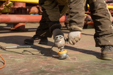 Kirli tulumlu bir işçi öğütücüyle çalışır..