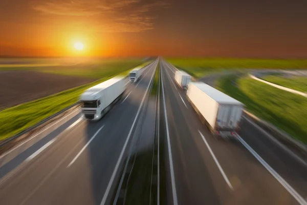 Camiones Reefer en movimiento borroso en la autopista vacía al atardecer —  Fotos de Stock