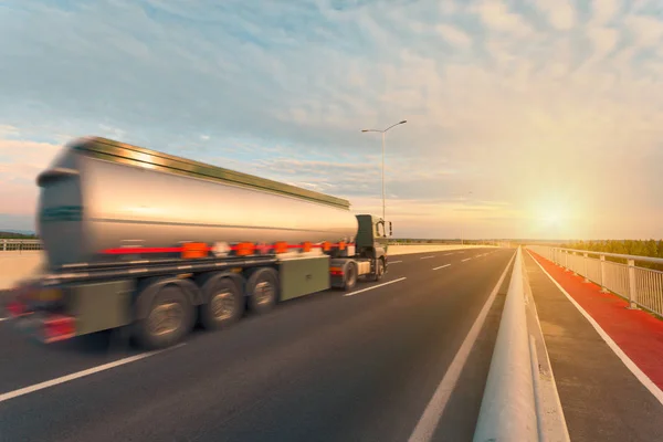 Tank truck on the empty highway at sunset — Stock Photo, Image