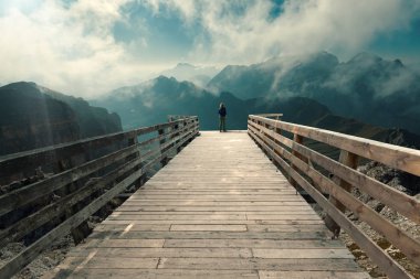 Genç kadın boardwalk dağlardan izlerken