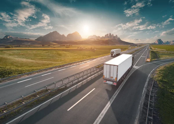 Zwei einsame weiße Lastwagen am sonnigen Morgen auf der Autobahn — Stockfoto