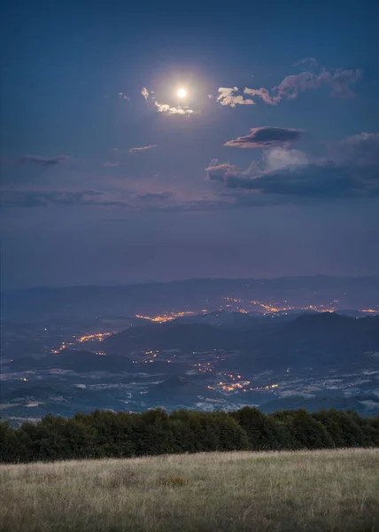 Hermoso paisaje en la noche de luna llena con vista a la ciudad — Foto de Stock