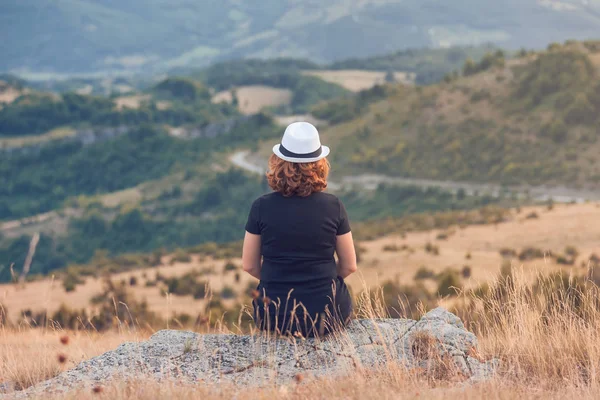 Jeune femme hipster en montagne assis sur le rocher et profiter — Photo