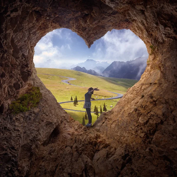 Lone woman in heart shape cave towards the idyllic scenery — Stock Photo, Image