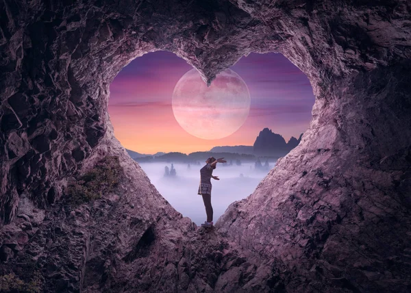 Single woman in heart shape cave towards the idyllic scenery — Stock Photo, Image