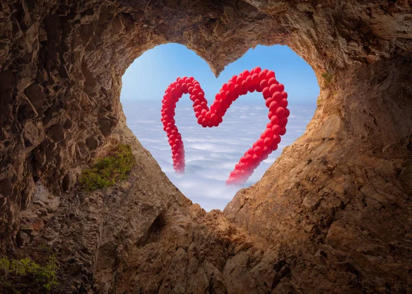 View from heart shape cave to the idyllic scene with baloons — Stock Photo, Image