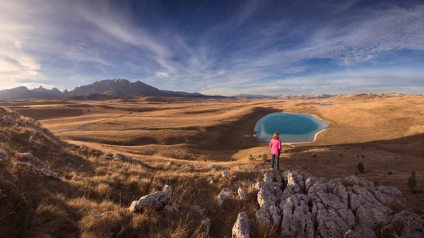 Frau auf Klippe mit Blick auf den Bergsee — Stockfoto