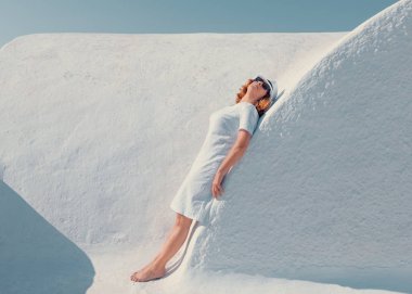 Beyaz elbise kavisli duvar üzerinde poz kadınla