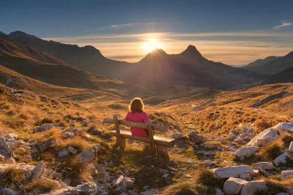 Woman on bench looking out at view of the mountain landscape — Stock Photo, Image
