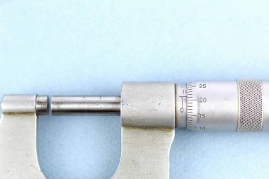 Eski mekanik mikrometre. Işık arkaplanındaki ölçüm aracı.