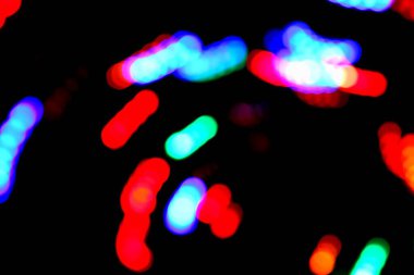 Boke. Gece şehrinin çok renkli aydınlatması. Renkli noktalar, siyah arkaplan.