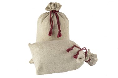 İki dekoratif çanta, beyaz arka planda izole edilmiş kaba kumaştan bir dantelle bağlanmış..