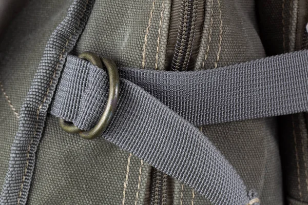 Fragment of a textile backpack with zippers and zippers. Textured pattern of coarse interwoven threads.