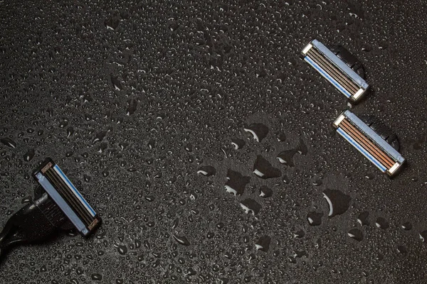 Male shaving machine on a black stone surface in drops of water. — Stock Photo, Image