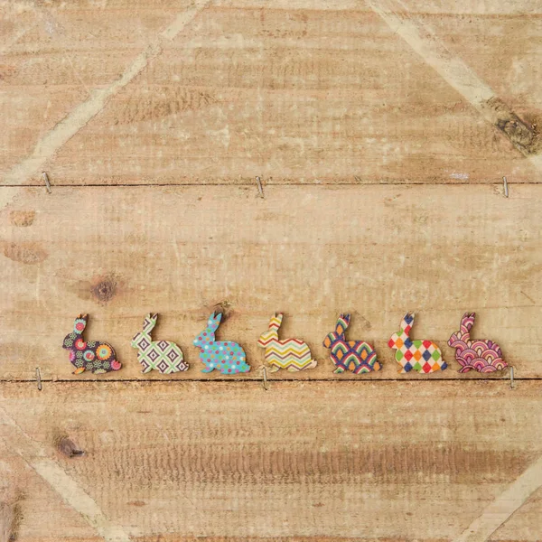 Veelkleurige konijntjes op houten achtergrond — Stockfoto