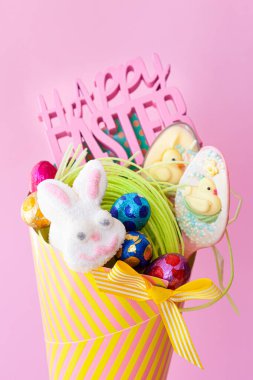 Neşeli paskalya ziyafetleri ve çikolatalarla renkli kağıt koniler.