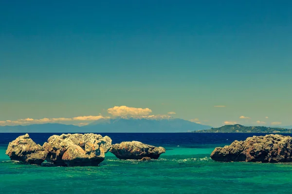 De rotsachtige kust met uitzicht op de azuurblauwe zee in warme summe — Stockfoto