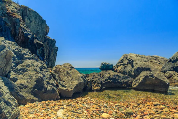 De rotsachtige kust met pijnboom met uitzicht over de turquoise blauwe se — Stockfoto