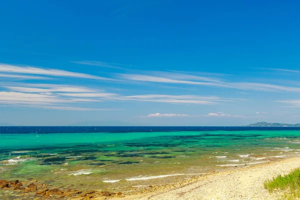 De rotsachtige kust met uitzicht op de turquoise blauwe en groene zee — Stockfoto