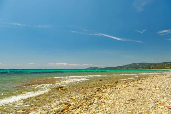 De rotsachtige kust met uitzicht op de turquoise blauwe zee in warme summa — Stockfoto