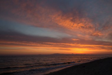 Gelgit sırasında sakin deniz kıyısında bahar turuncu şafak.