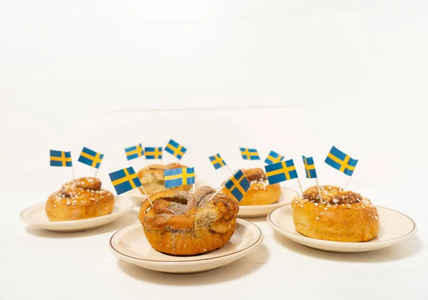 Svenska Kanelbullar Kanelbullar Det Vita Träbordet Svenska Flaggor Kaffepaus Fika — Stockfoto