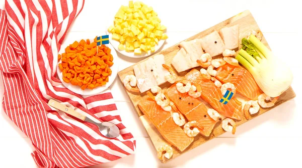 茴香在木板上 白盘里的土豆和胡萝卜 勺子和条纹桌布 瑞典国旗 传统斯堪的纳维亚鱼汤的配料 瑞典食品 — 图库照片