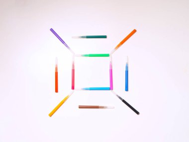 Beyaz arka planda renkli keçeli kalemler. Kare şeklinde işaretler. Geçmişi ya da dokusu. Metin için yer.