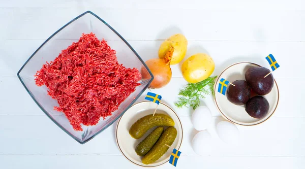 Ingredients for a traditional Swedish dish beef Lindstrom. Freshly minced beef, boiled potato, white chopped onion, pickles, pickled red beets, eggs. Swedish cuisine. Scandinavian cuisine.