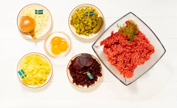 Ingredients for a traditional Swedish dish beef Lindstrom. Freshly minced beef, boiled potato, white chopped onion, pickles, pickled red beets, eggs. Swedish cuisine. Scandinavian cuisine.