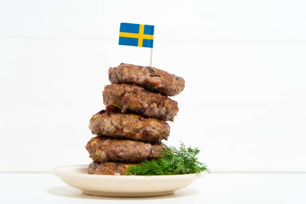 Traditional Swedish dish beef Lindstrom. In the plate with dill. Swedish flag.  Swedish cuisine. Scandinavian cuisine.