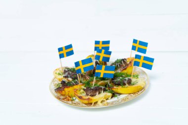 Patates dolması. İsveç bayrağı. Patates, kıyma, soğan, havuç, peynir, sarımsak, dereotu. İsveç mutfağı. İskandinav yemeği. Metin için yeri olan arkaplan.