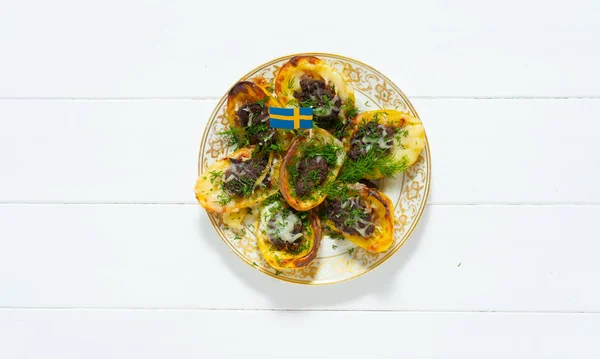 Stuffed potatoes. Swedish flag. Potatoes, minced meat, onion, carrot, cheese, garlic, dill. Swedish cuisine. Scandinavian food. Background with place for text.