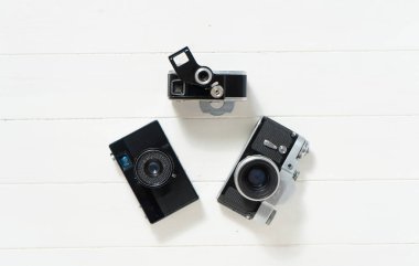 Beyaz ahşap arka planda klasik kameralar. Eski teknoloji kavramı. Mesajlar için yeri olan fotoğraf. İsveç. İskandinavya. Üst görünüm, düz görünüm.