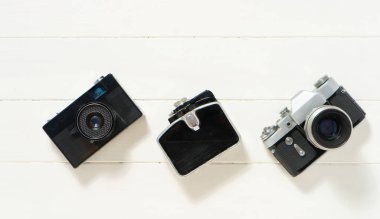 Beyaz ahşap arka planda klasik kameralar. Eski teknoloji kavramı. Mesajlar için yeri olan fotoğraf. İsveç. İskandinavya. Üst görünüm, düz görünüm.