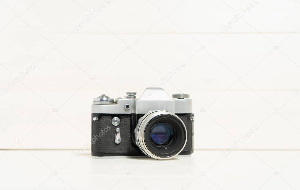 Vintage camera on the white wooden background. Concept of old technology. Photo with place for text. Sweden. Scandinavia.