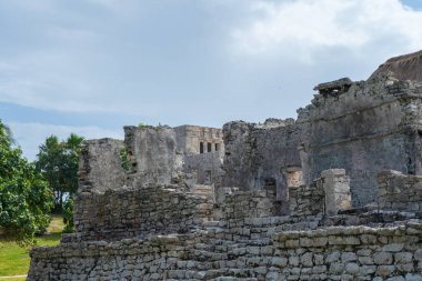 Ruins of ancient Tulum. Architecture of ancient maya. View with temple and other old buildings, houses. Blue sky and lush greenery of nature. travel photo. Wallpaper or background. Yucatan. Mexico.