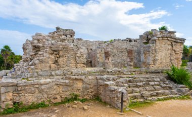 Ruins of ancient Tulum. Architecture of ancient maya. View with temple and other old buildings, houses. Blue sky and lush greenery of nature. travel photo. Wallpaper or background. Yucatan. Mexico.