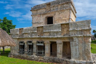 Ruins of ancient Tulum. Architecture of ancient maya. View with temple and other old buildings, houses. Blue sky and lush greenery of nature. travel photo. Wallpaper or background. Yucatan. Mexico.