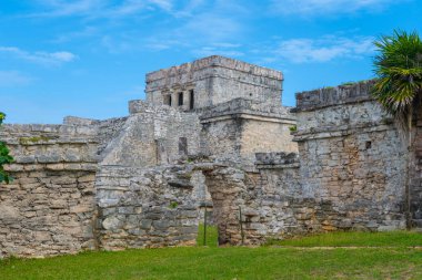 Ruins of ancient Tulum. Architecture of ancient maya. View with temple and other old buildings, houses. Blue sky and lush greenery of nature. travel photo. Wallpaper or background. Yucatan. Mexico.