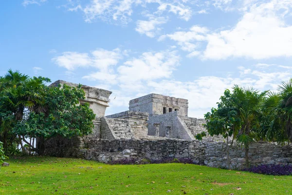 Ruins of ancient Tulum. Architecture of ancient maya. View with temple and other old buildings, houses. Blue sky and lush greenery of nature. travel photo. Wallpaper or background. Yucatan. Mexico.