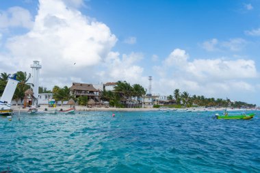 Puerto Morelos deniz manzaralı ve tekneli. Bulutlu Karayip gökyüzü. Beyaz kum kıyısı. Arkaplan ya da duvar kağıdı. Yucatan. Quintana Roo. Meksika mı? Riviera maya.