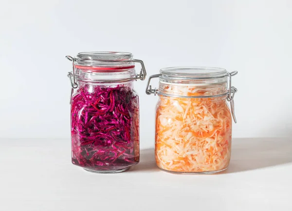 Homemade sauerkraut with carrots and cabbage salad with beets in a glass jar on a white wooden background. Fermented food. — Stock Image Homemade sauerkraut with carrots and cabbage salad with beets in a glass jar on a white wooden background. Fermented food. Stock Picture