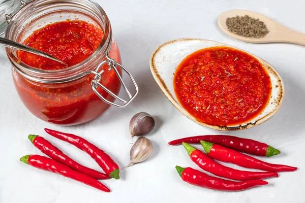 Hot chili pepper sauce paste harissa. Adjika. Traditional Tunisia, Georgian and Arabic cuisine. Homemade rose harissa in a bowl.