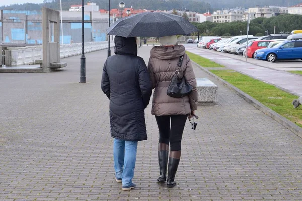 Deux femmes dans la rue avec des parasols sous la pluie — Photo